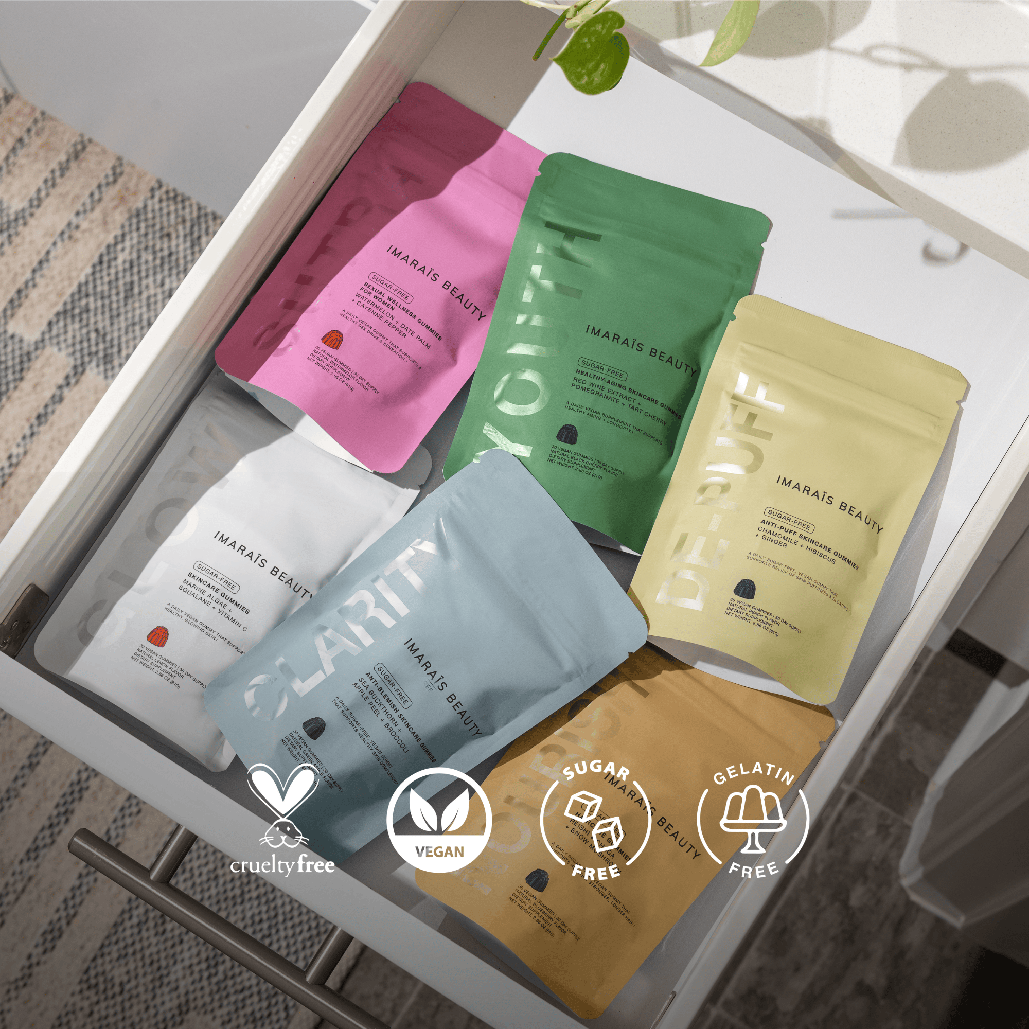 Flat lay of Imaraïs Beauty gummy supplement pouches neatly arranged in a drawer, showcasing the full product lineup. Visible icons highlight that the products are cruelty-free, vegan, sugar-free, and gelatin-free.