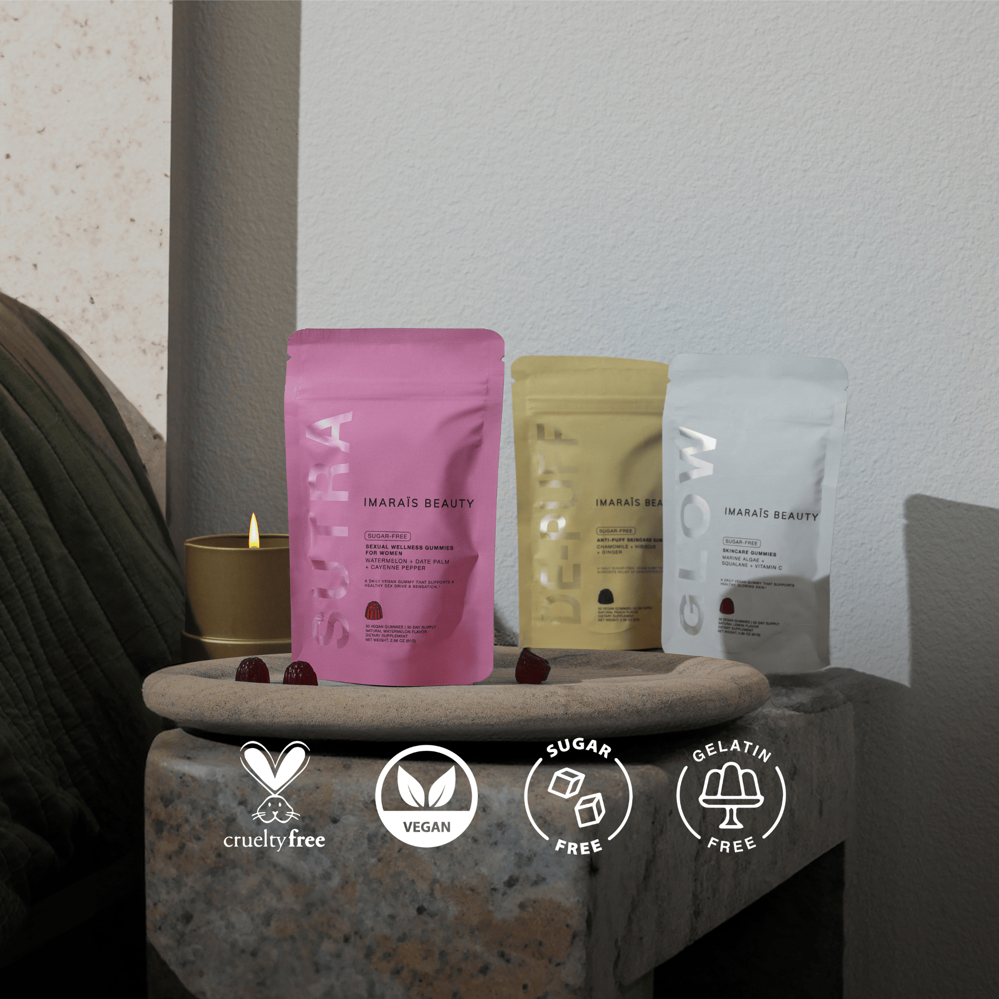 Three Imaraïs Beauty gummy supplement pouches displayed on a stone tray in a serene setting, emphasizing wellness and relaxation. Cruelty-free, vegan, sugar-free, and gelatin-free icons are shown at the bottom.