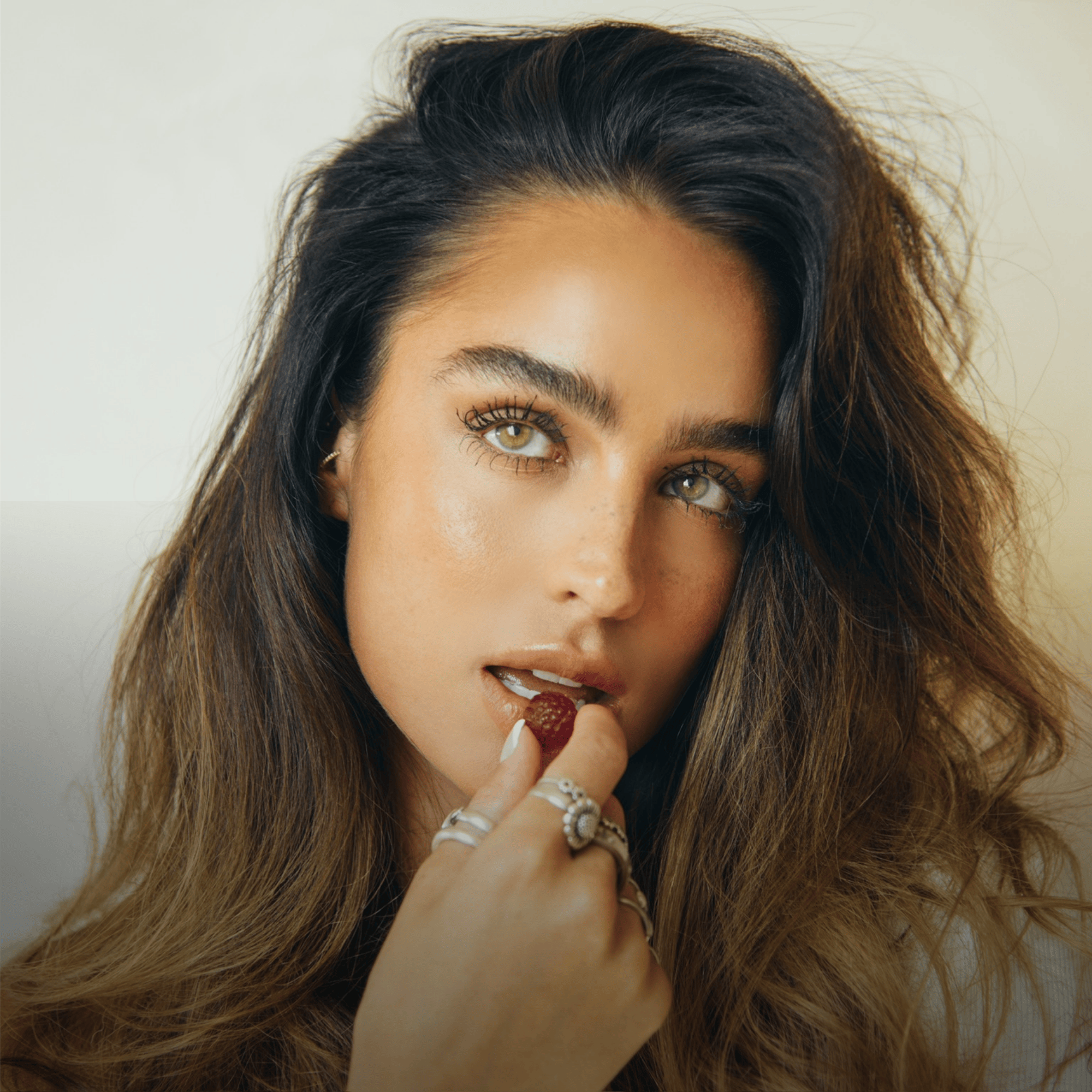 Close-up of model Sommer Ray about to enjoy an Imarais Beauty gummy, highlighting her glowing skin and relaxed, luxurious vibe.